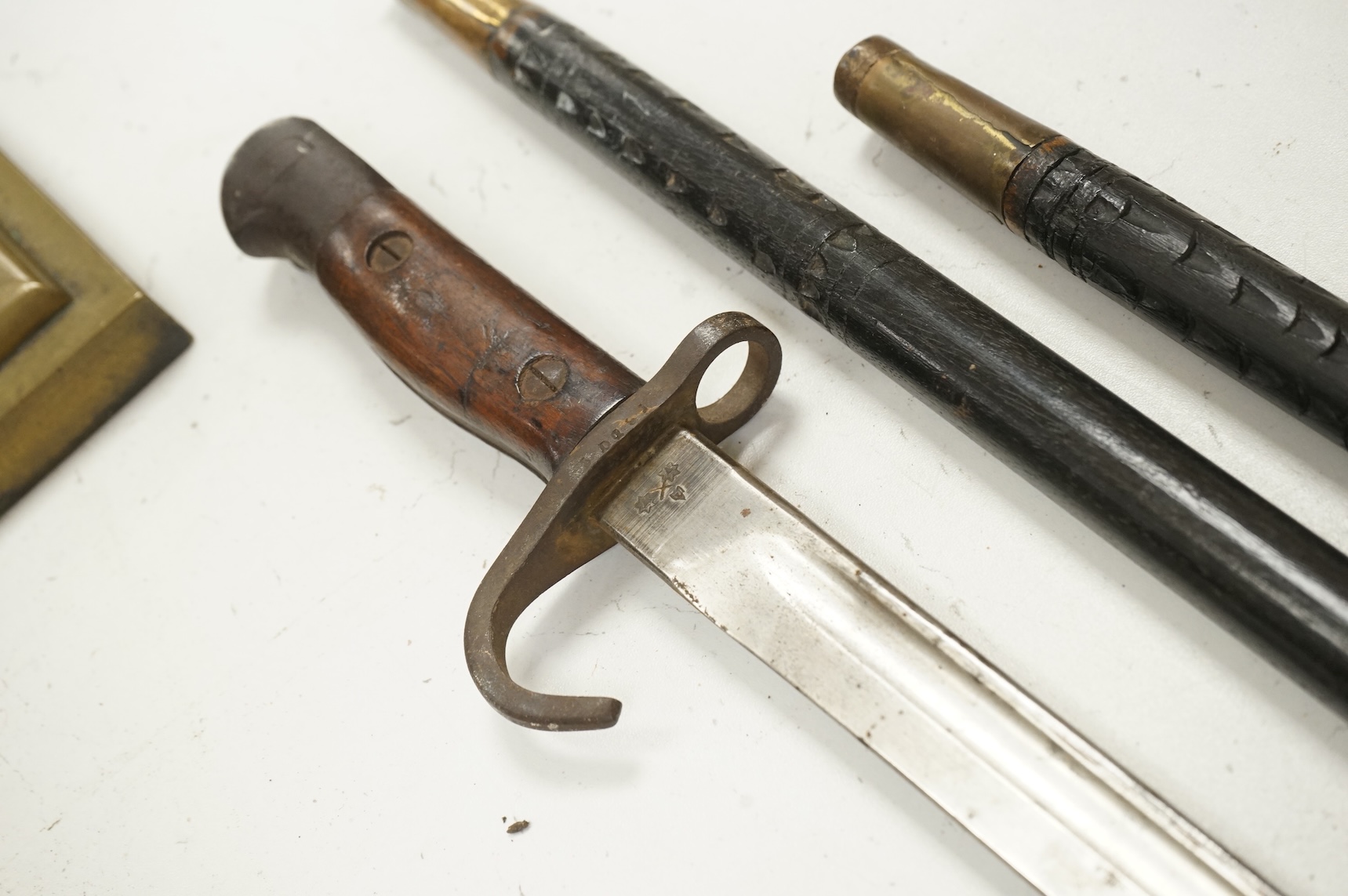 Three early 20th century Indonesian bone overlaid sword sticks and a bayonet, largest 92cm in length